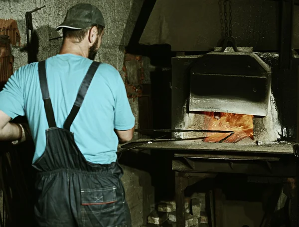 Trabajando en la fábrica de estufas de hierro Imagen de archivo