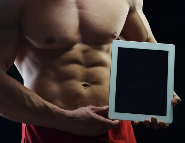 Body builder campione in posa in studio con tablet — Foto Stock