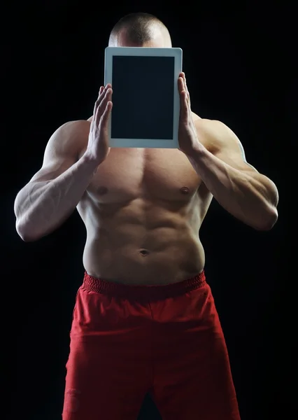 Corpo construtor campeão posando em estúdio com tablet — Fotografia de Stock