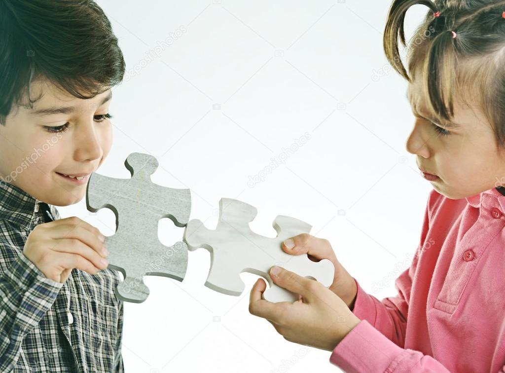 Kids connecting the jigsaw puzzle