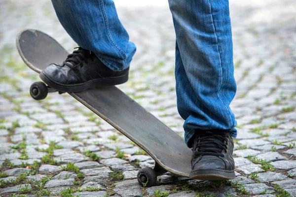 Nohy na skateboardu v dlážděné ulici — Stock fotografie