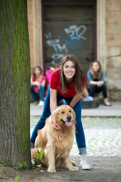 Schönes Teenager-Mädchen, das einen Hund knuddelt — Stockfoto