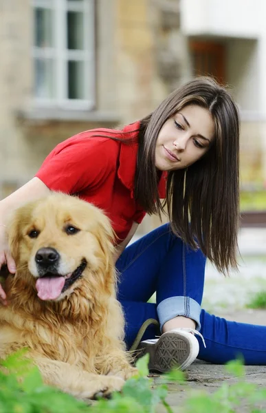 Menina adolescente bonita abraçando um cão — Fotografia de Stock