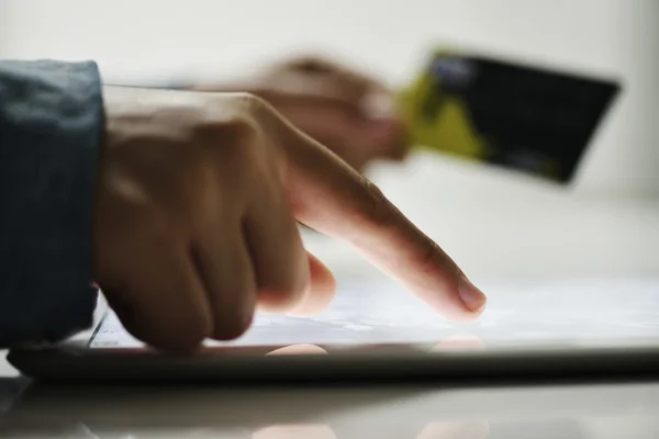 Mano humana en la tableta PC y tarjeta de crédito —  Fotos de Stock