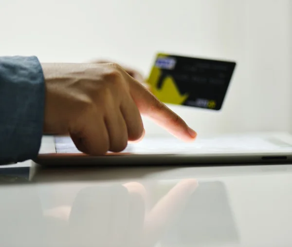 Mano humana en la tableta PC y tarjeta de crédito — Foto de Stock