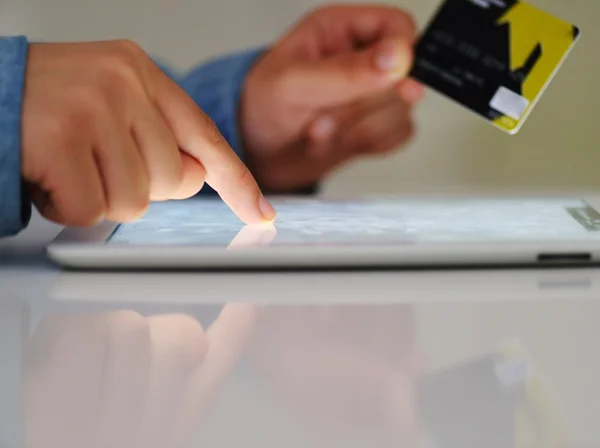 Mano humana en la tableta PC y tarjeta de crédito — Foto de Stock
