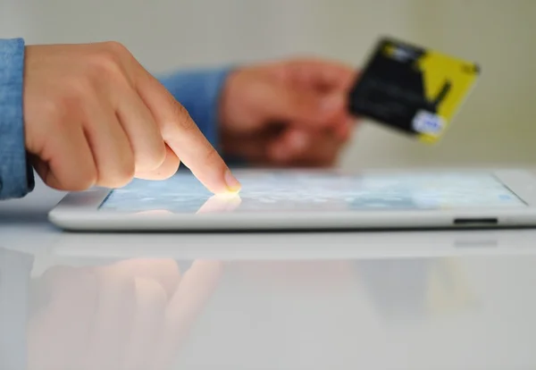Mano humana en la tableta PC y tarjeta de crédito —  Fotos de Stock