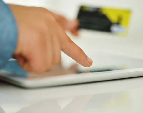 Mano humana en la tableta PC y tarjeta de crédito — Foto de Stock