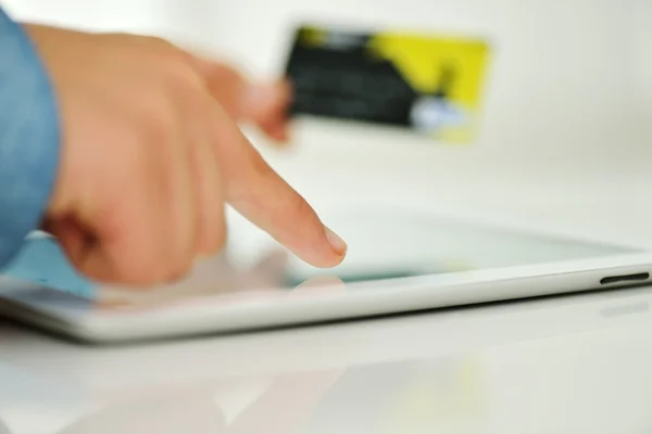 Mano humana en la tableta PC y tarjeta de crédito — Foto de Stock