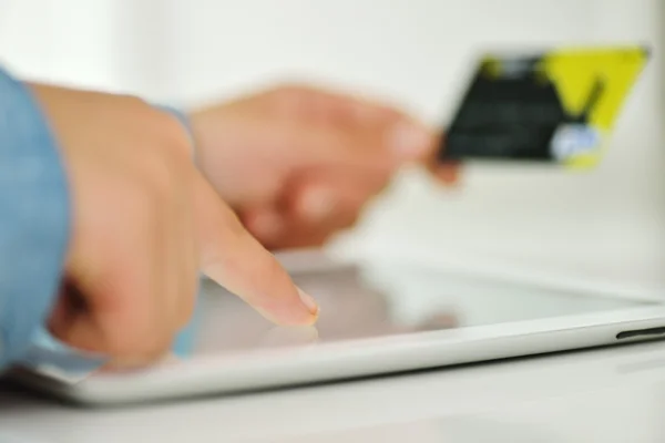 Mano humana en la tableta PC y tarjeta de crédito — Foto de Stock