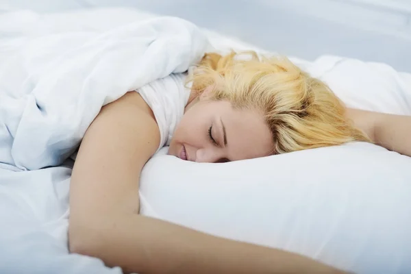Kvinna på säng i sovrummet vaknar — Stockfoto