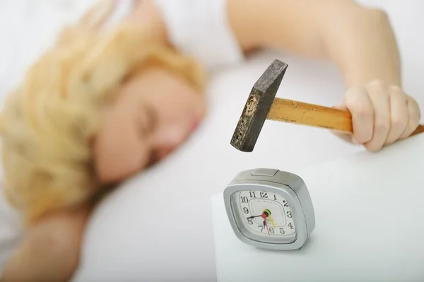 Weibchen auf Bett im Schlafzimmer mit Uhr — Stockfoto