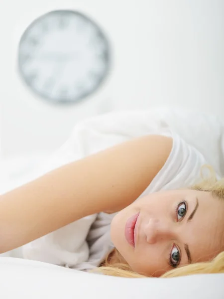 Feminino na cama no quarto com relógio — Fotografia de Stock