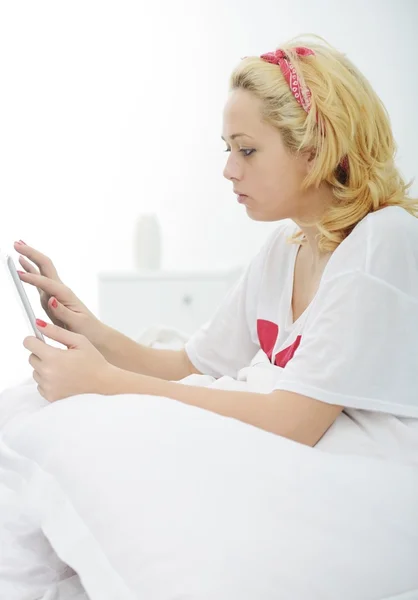 Menina loira feliz na cama no quarto — Fotografia de Stock