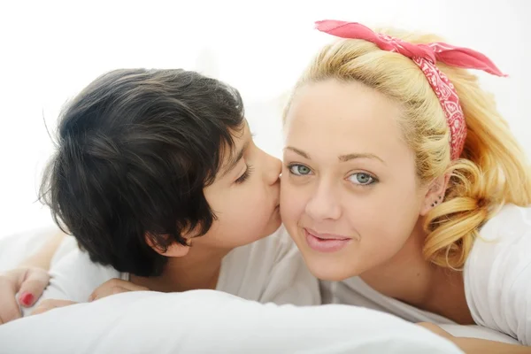 Glückliche junge Mutter mit ihrem Sohn im Bett — Stockfoto