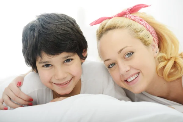 Joyeux jeune mère avec son fils au lit — Photo