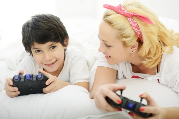 Gelukkig jonge moeder met haar zoon in bed — Stockfoto