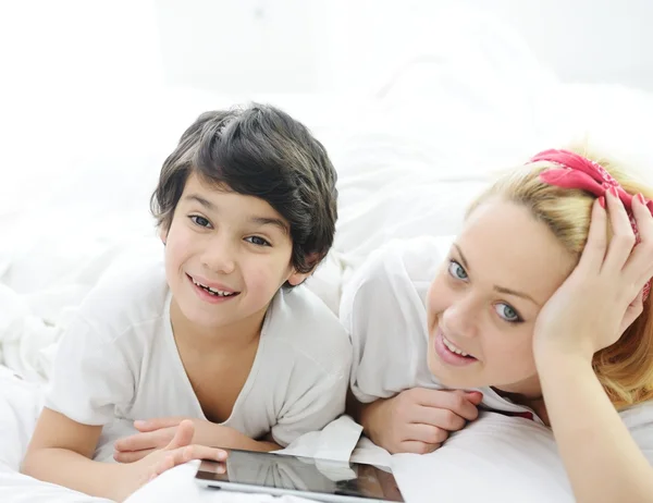 Loira feliz jovem mãe com seu filho na cama — Fotografia de Stock