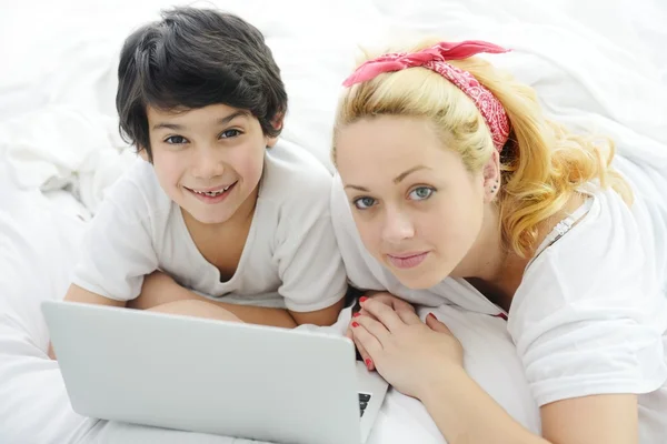 Happy blonde young mother with her son in bed — Stock Photo, Image