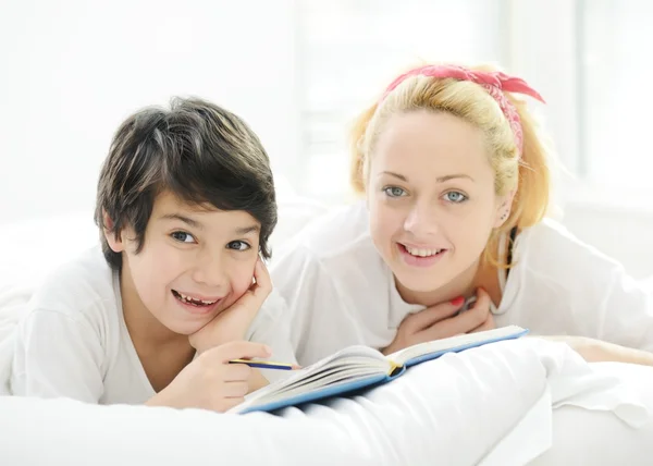 Glad blondin ung mamma med sin son i sängen — Stockfoto