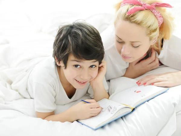 Loira feliz jovem mãe com seu filho na cama — Fotografia de Stock