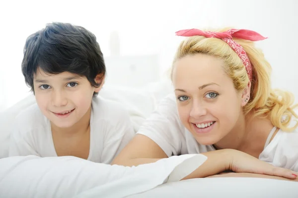 Szczęśliwa młoda matka z synem w łóżku Zdjęcia Stockowe bez tantiem