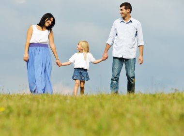 Genç aile eğleniyor yeşil yaz çimen çayır üzerinde