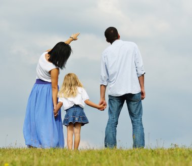 Genç aile eğleniyor yeşil yaz çimen çayır üzerinde