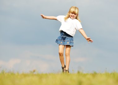 Llittle sarışın kız yaz çimen çayır üzerinde