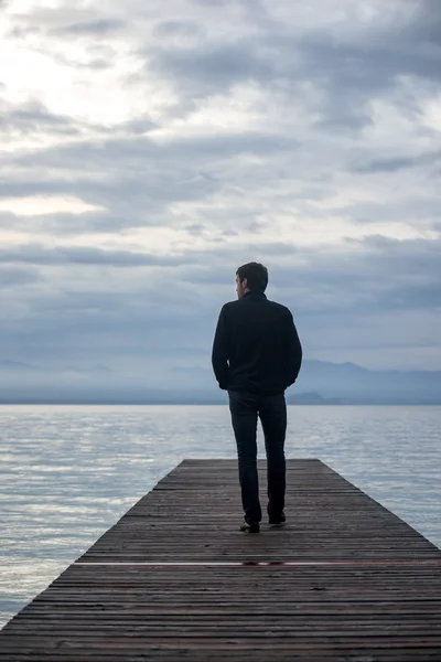 Uomo che cammina sul molo — Foto Stock