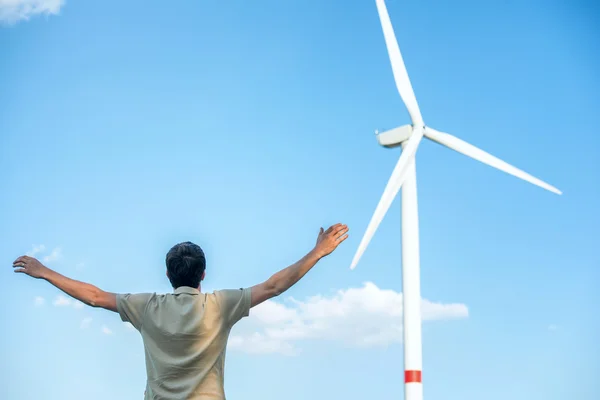 Uomo in piedi vicino alla turbina eolica — Foto Stock