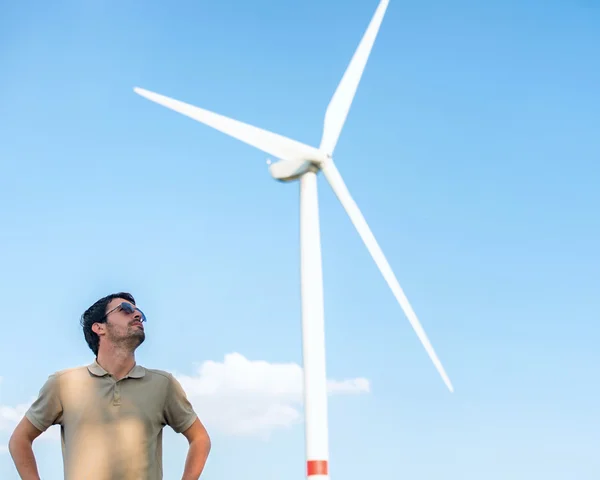 Hombre parado junto al aerogenerador —  Fotos de Stock