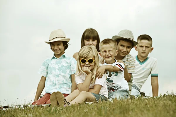 Niños felices en el prado de hierba de verano —  Fotos de Stock