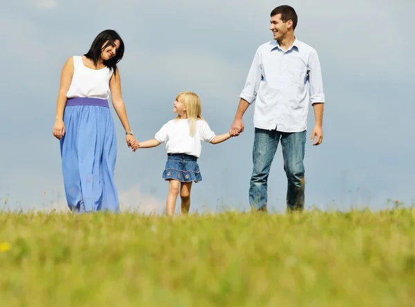 Jeune famille sur prairie verte d'herbe d'été s'amuser — Photo