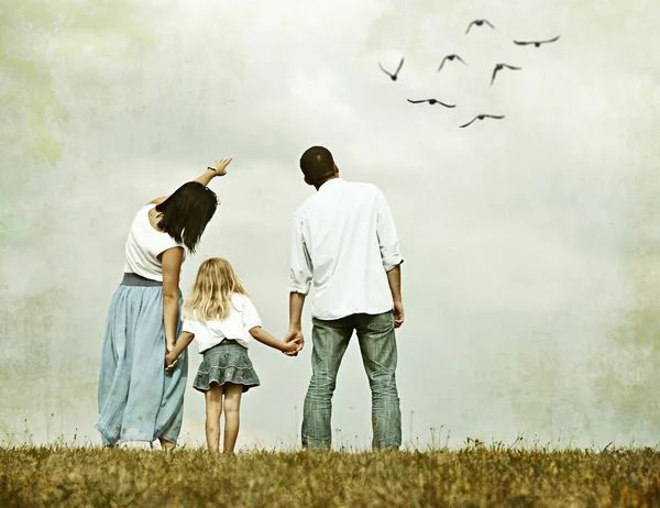 Jeune famille sur prairie verte d'herbe d'été s'amuser — Photo