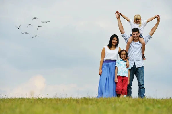 Familia feliz en la naturaleza caminando en el verde prado de verano —  Fotos de Stock