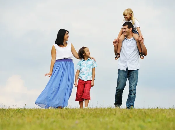 Glückliche Familie in der Natur beim Wandern auf der grünen Sommerwiese — Stockfoto