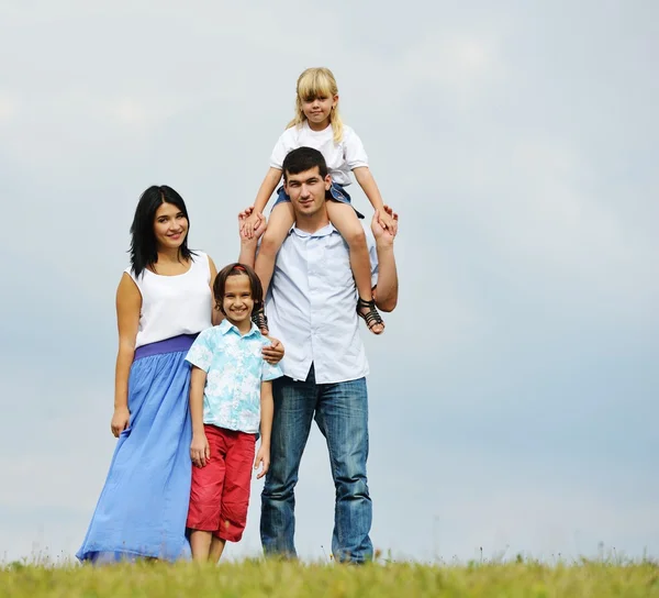 Famiglia felice nella natura passeggiare sul prato verde estivo Foto Stock