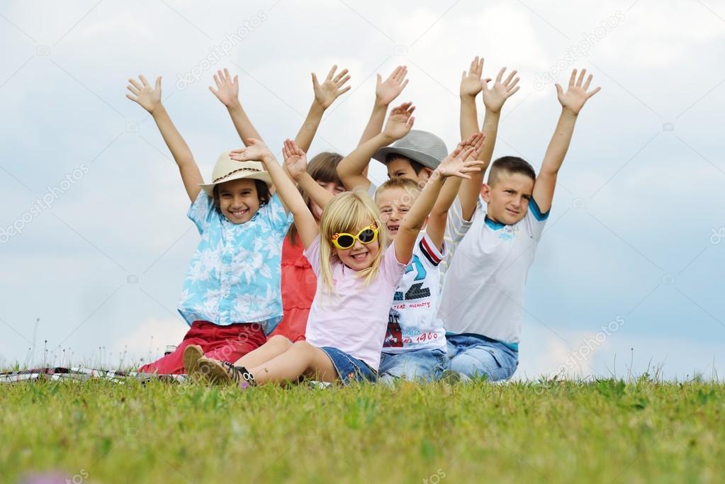 Happy children on summer grass meadow