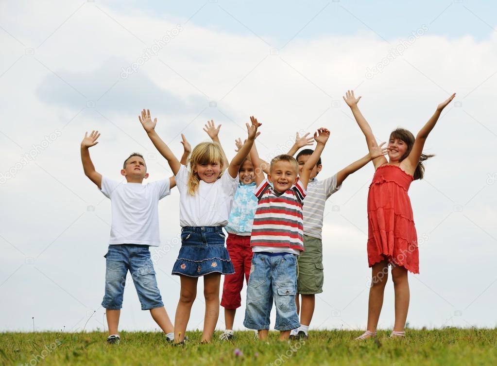 Happy children on summer grass meadow