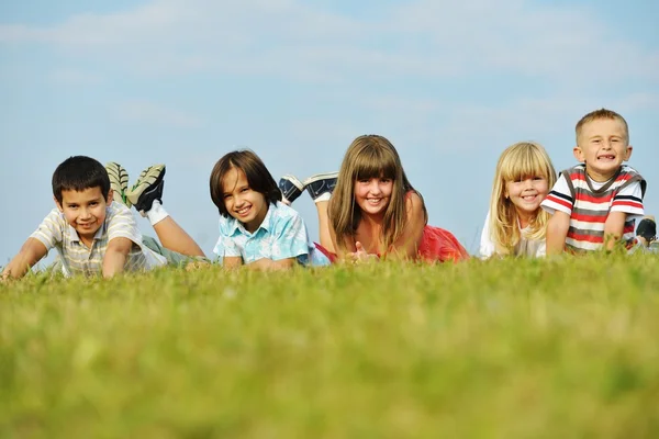 Groep gelukkige kinderen op zomer gras weide — Stockfoto