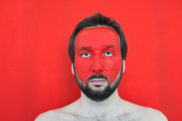 Painting in red man's face — Stock Photo, Image