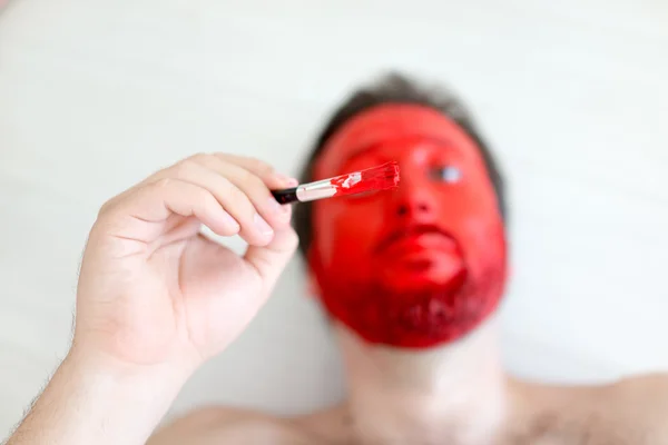 Живопись на лице красного человека — стоковое фото
