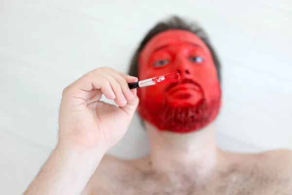 Pintura no rosto do homem vermelho — Fotografia de Stock