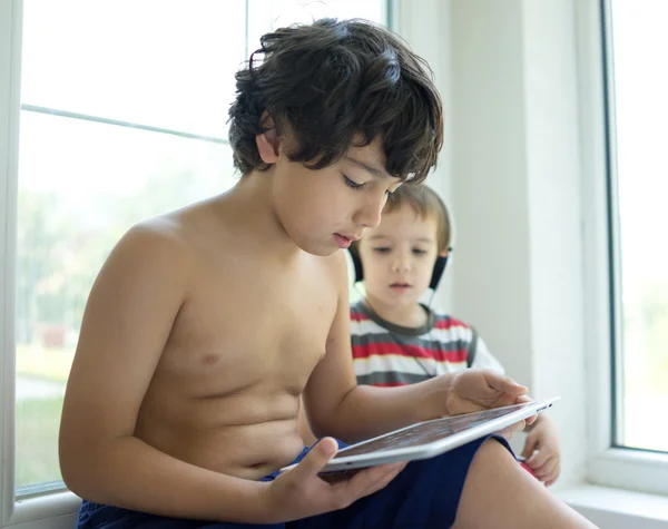 Dois irmãos com tablet em casa — Fotografia de Stock