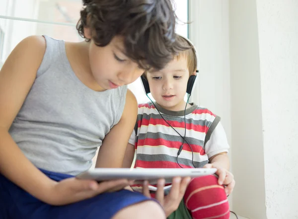 Dois irmãos com tablet em casa — Fotografia de Stock