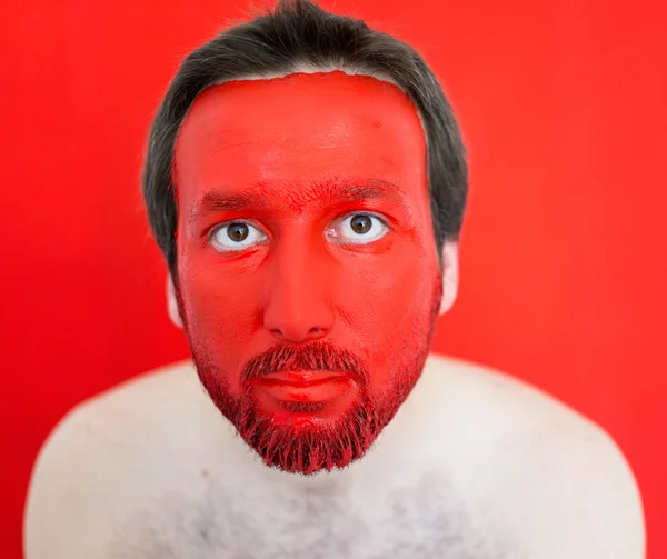 Человек с красным окрашенным лицом — стоковое фото