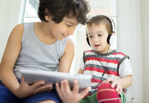 Dois irmãos com tablet em casa — Fotografia de Stock