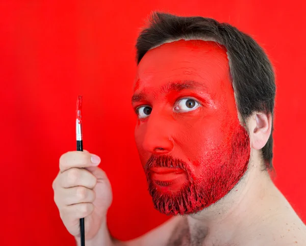 Живопись на лице красного человека — стоковое фото