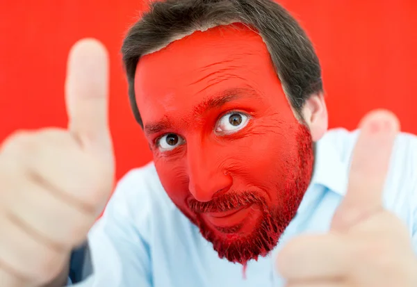 Retrato de jovem com rosto pintado de vermelho — Fotografia de Stock